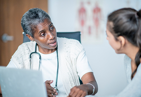 Physician speaking with someone in an office